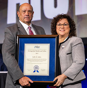 Tom Toner (left) presented the Distinguished Member and Fellow Award to Kelly M. Dallas (right).

