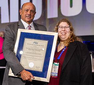 Tom Toner (left) presented the first-place Hunt-Kelly Outstanding Paper Award to Katelyn E. Kiser (right).